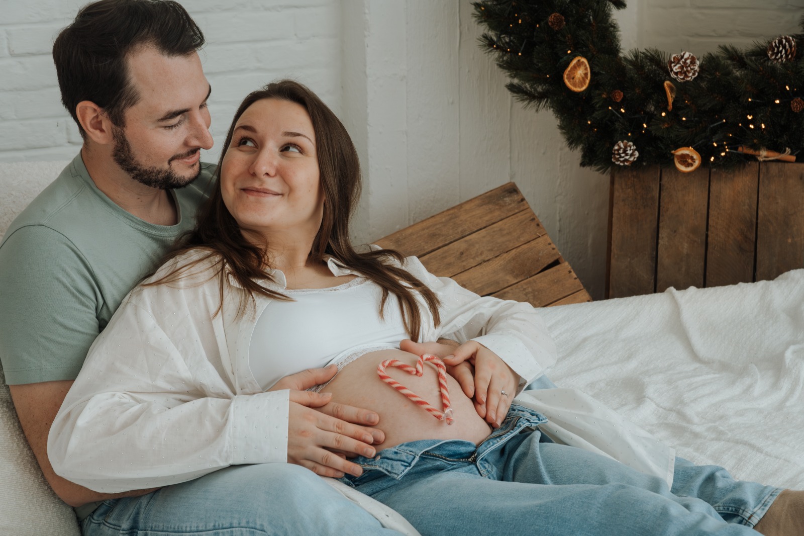 Zwangere vrouw met candy cane hart op de buik, kerstsfeer