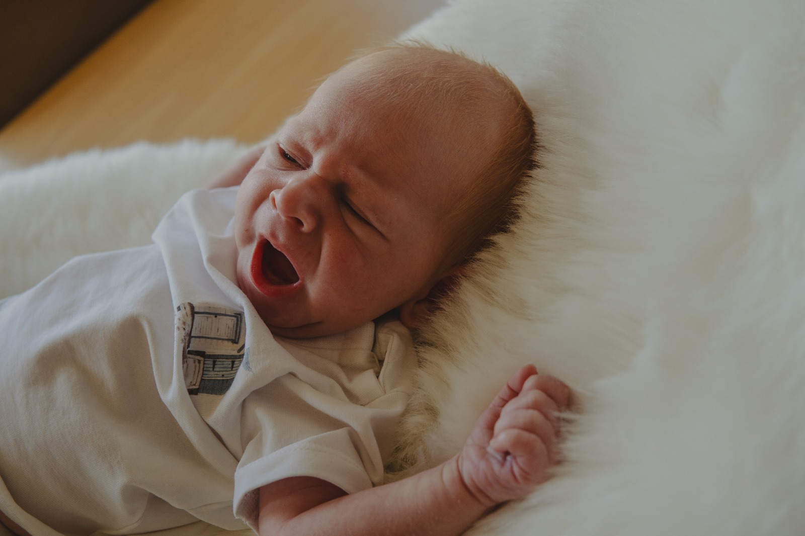 Newborn baby op een wit bontkleed